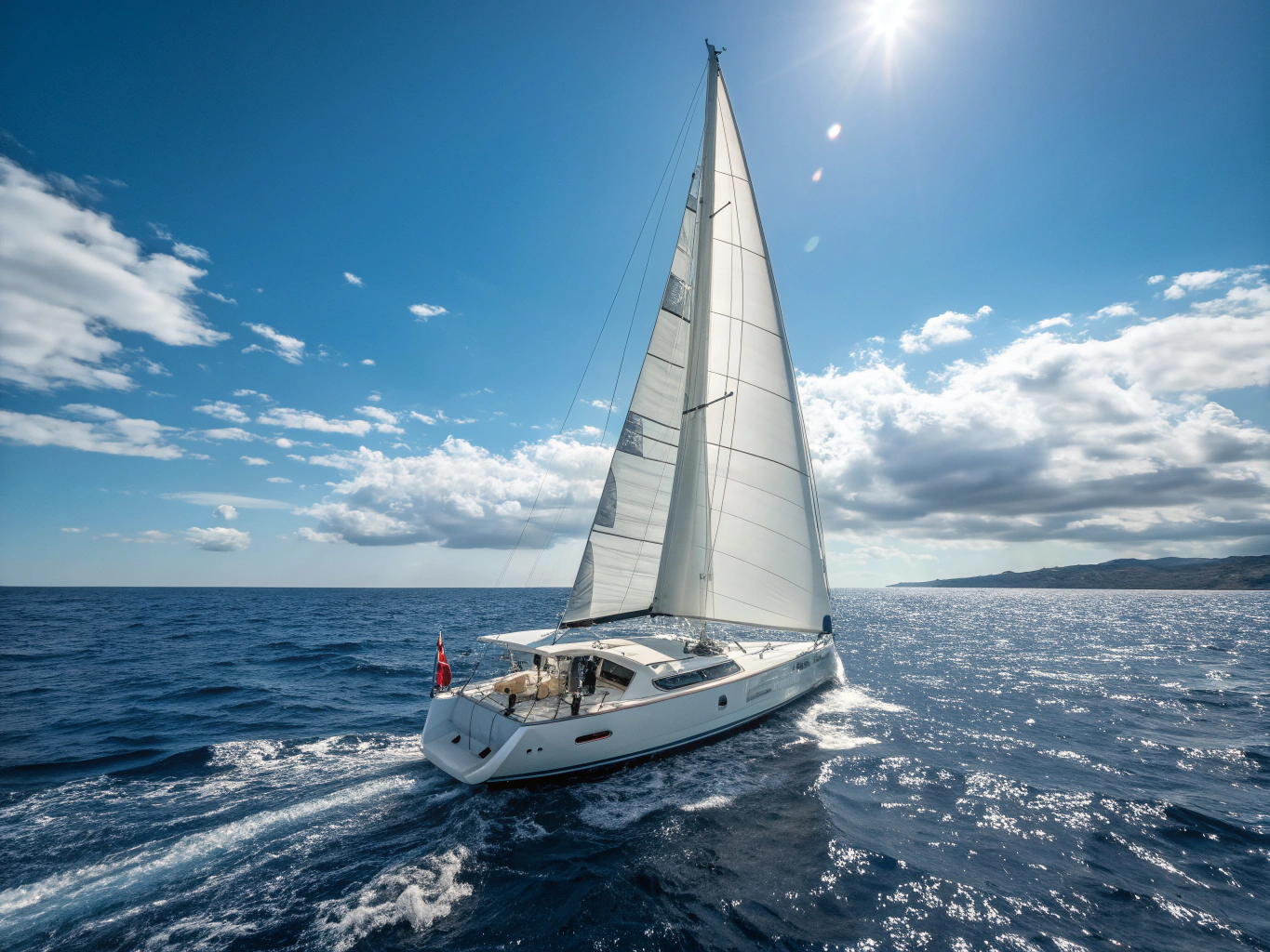 The Circus Wagon sailboat sailing under full white canvas across ocean swells